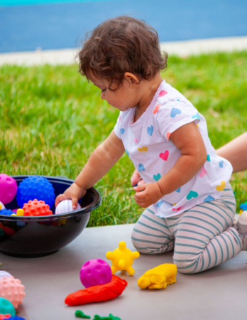 toddler placing balls in a basket