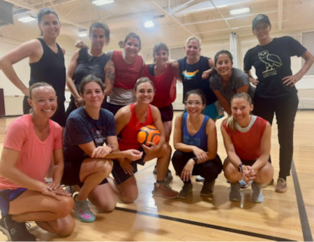 Twelve women futsal players pose in two rows at Stephens-Lee Community Center