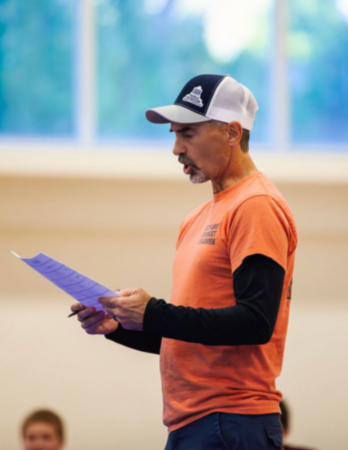 Asheville Parks & Recreation team member Bob Jackson reads wrestling rules to young people