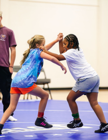  two young people wrestle on mats at Grant Southside Center