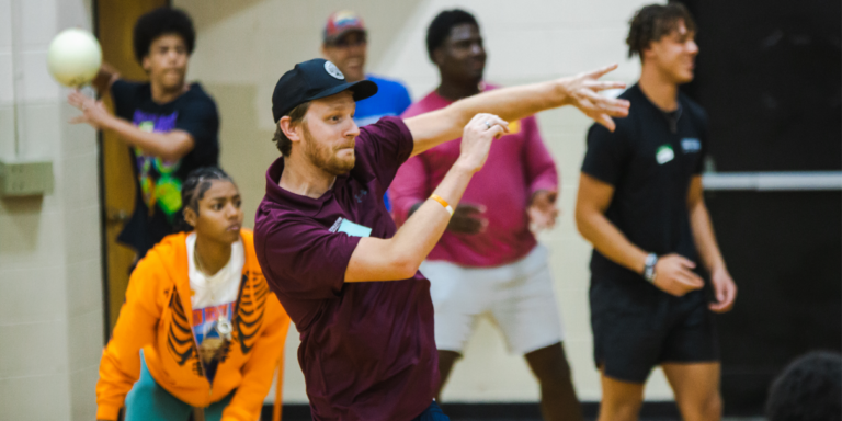 adults playing dodgeball in a gym