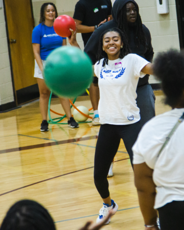adult smiling during indoor dodgeball game