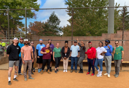 adults on a sports team standing on a ballfield