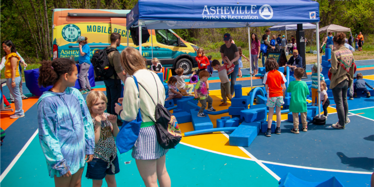 families playing games in front of the Rec ‘n’ Roll mobile recreation van
