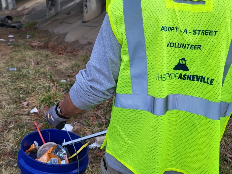 Volunteer picks up trash as part of the City's Adopt-a-Street program