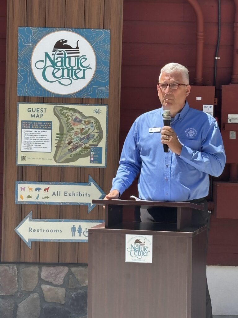 FAcility director chris gentile addressing crown from podium at ribbon cutting ceremony