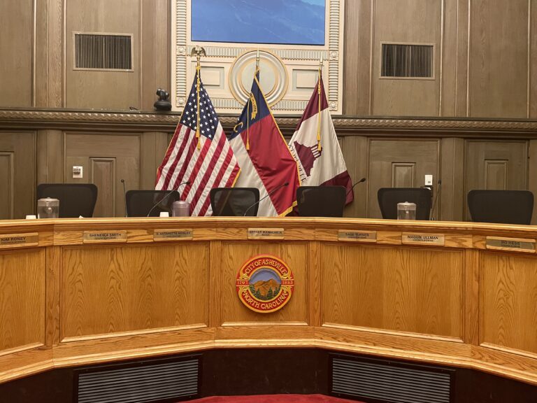 American , City and state flag behind empty dias seats