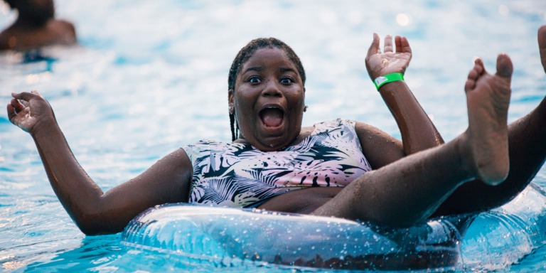 teen floating in inner tube in a pool