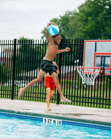 kid playing basketball in a pool