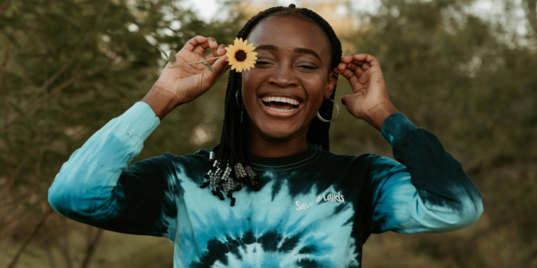 adult smiling in a tie dye shirt