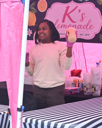 lemonade vendor holding a cup of lemonade