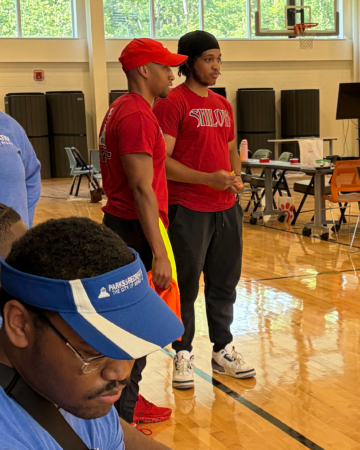 DeVonte talking to a coworker in a gym