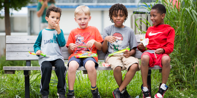 kids eating snacks on a bench