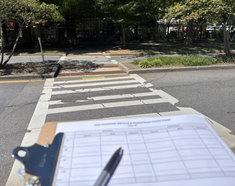clipboard with a survey form and a pen near a crosswalk in downtown Asheville