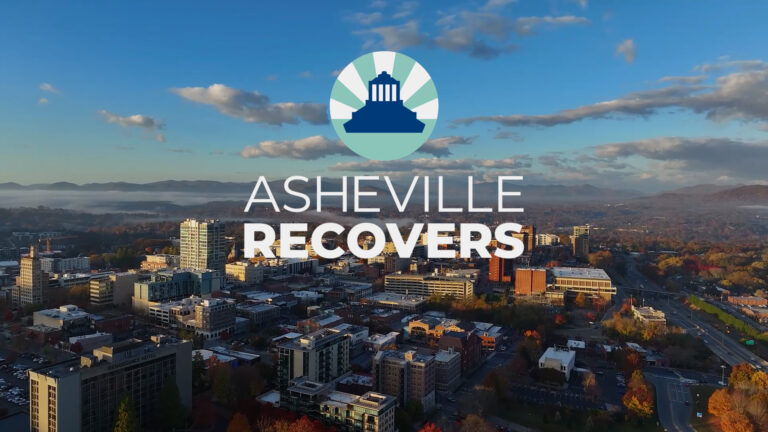 aerial shot of City with words Asheville Recovers superimposed